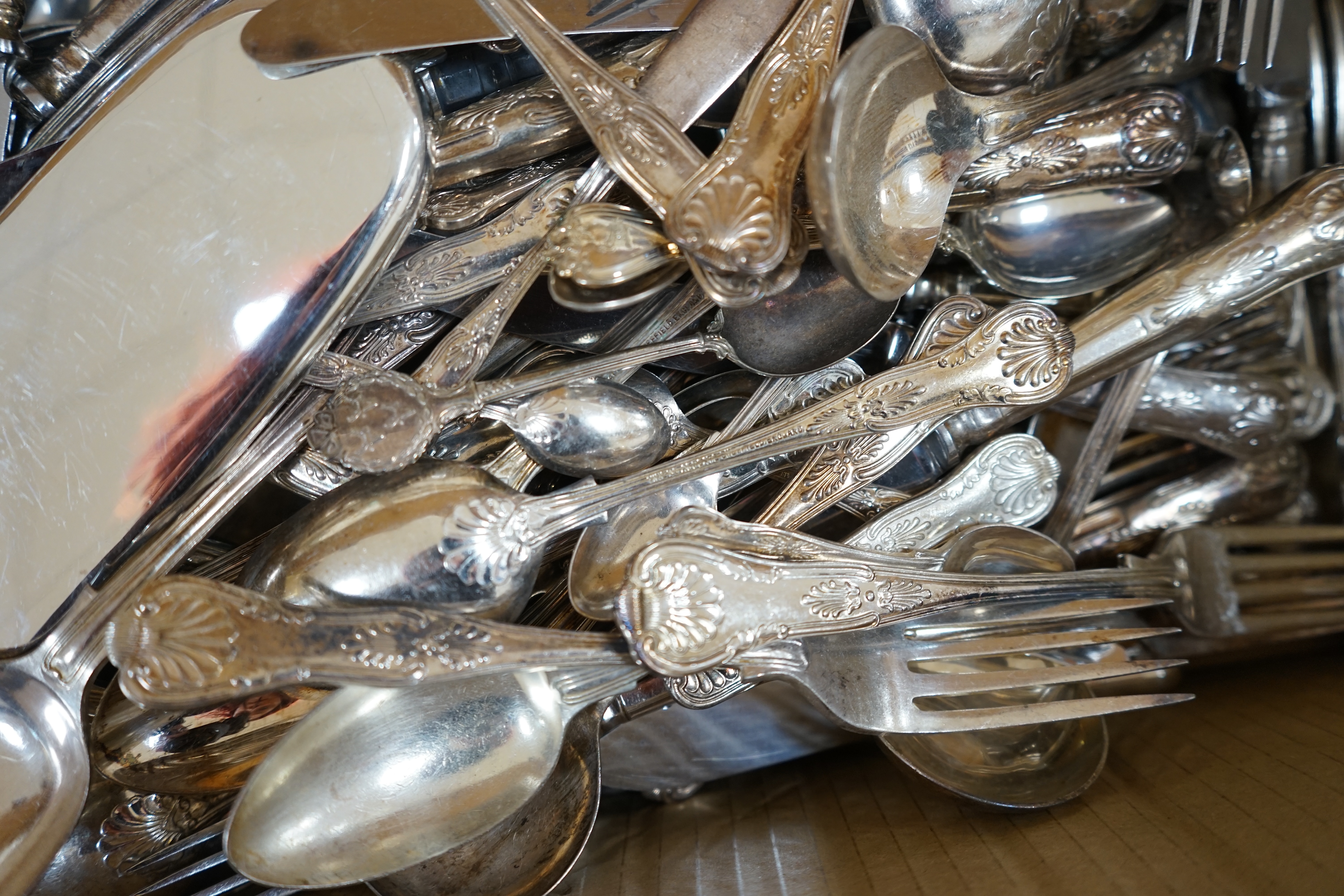 A large quantity silver plated cutlery including a part canteen of King's pattern cutlery and beaded pattern cutlery, a plated sugar basket, together with a mahogany, velvet lined box, 38cm wide. Condition - fair